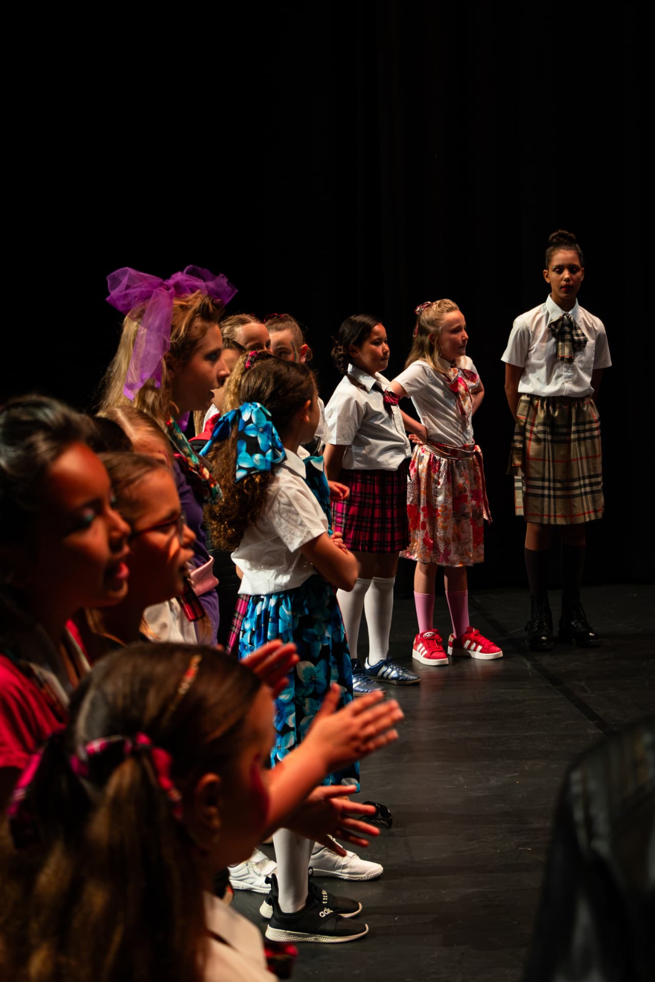 Kinderen in kostuum staan stil in de scène onder het theaterlicht