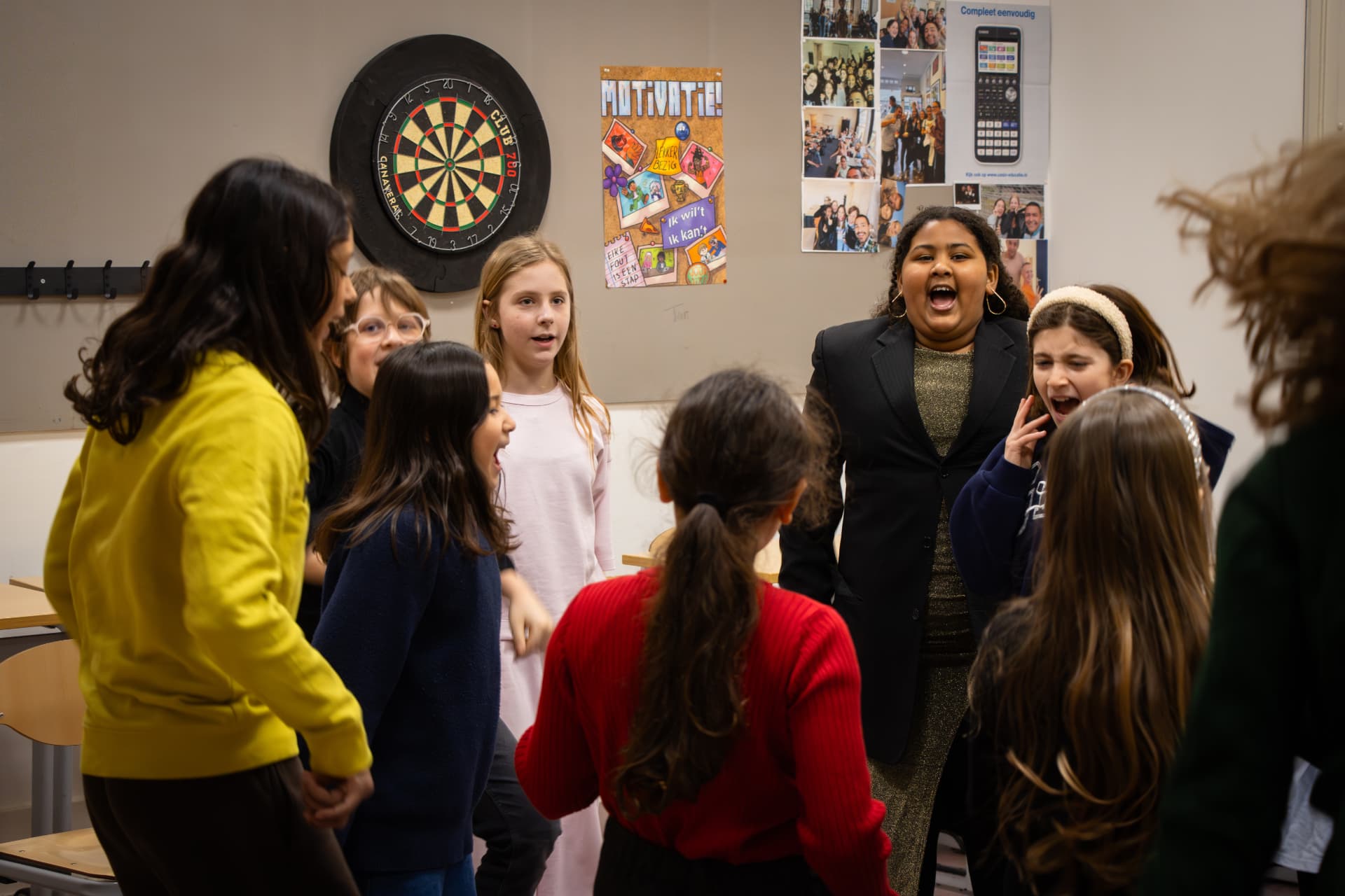 Kinderen uit de oudste groep zingen samen in een kring tijdens de zangles