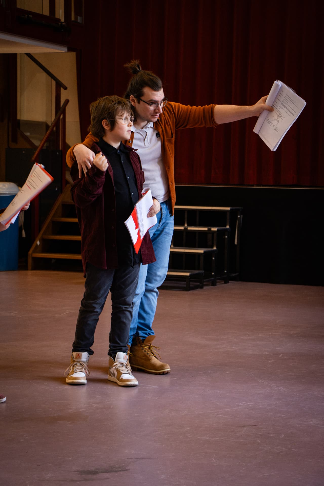 Theaterdocent Rob repeteert samen met een leerling in de aula
