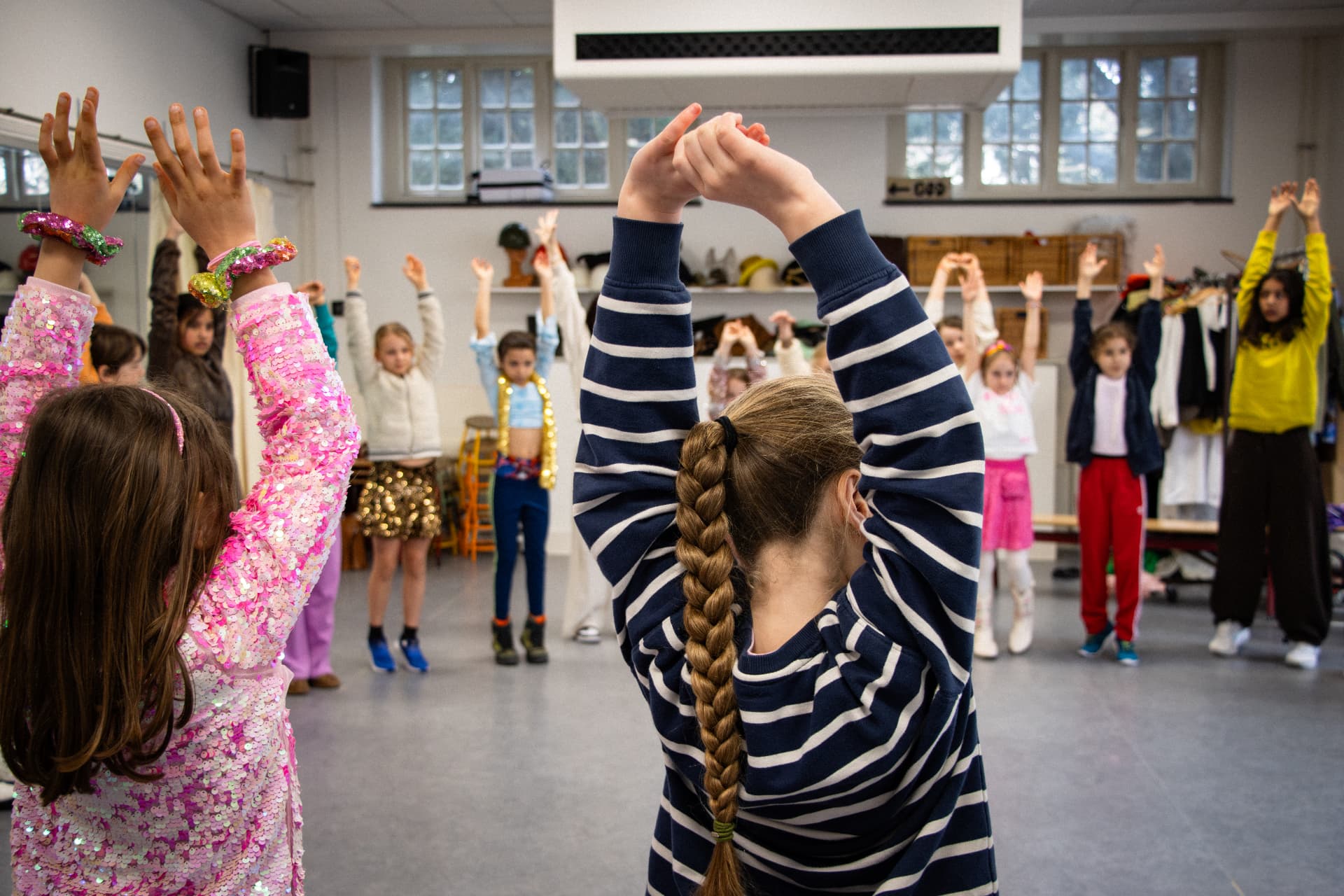 Kinderen strekken hun armen omhoog tijdens de gezamenlijke warming-up